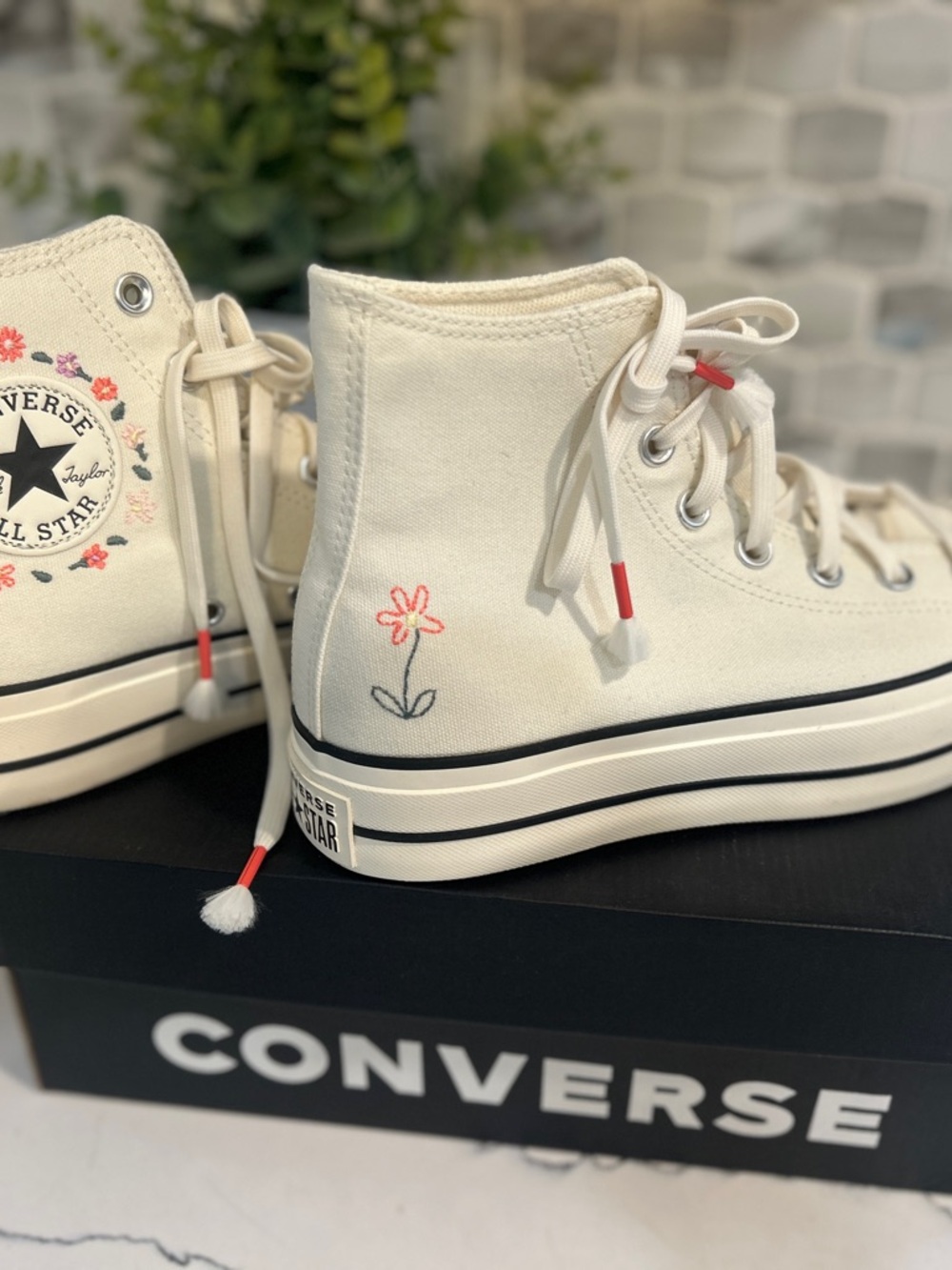 Platform Converse high-top sneakers in cream with pink floral embroidery.